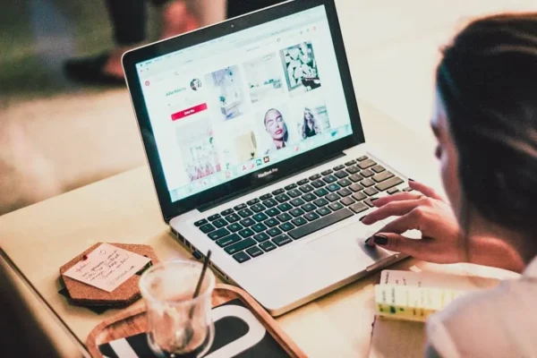 Mulher criando pins no Canva com ajuda do ChatGPT em laptop